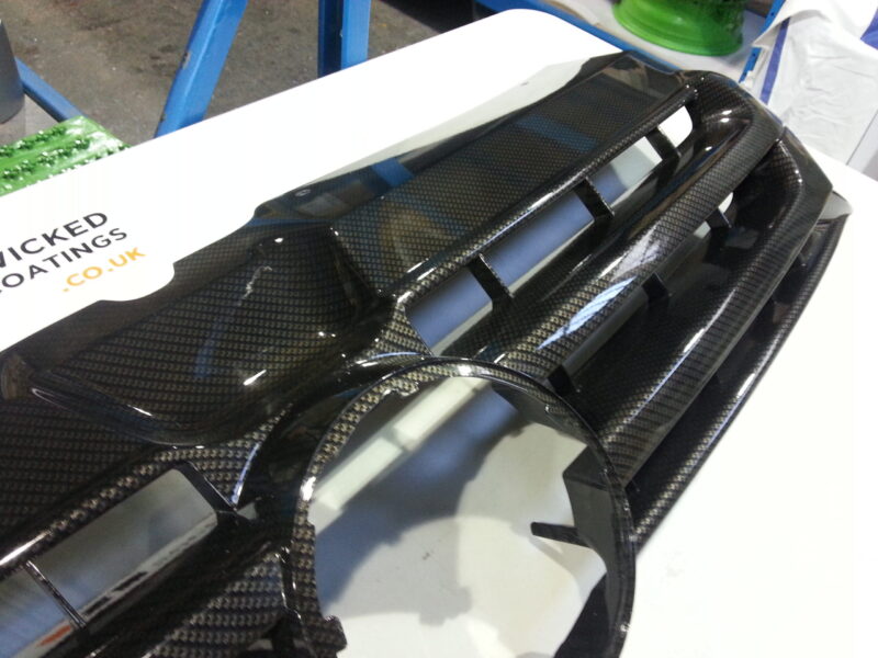 VW radiator grill coated in carbon fibre hydrographic film painted black