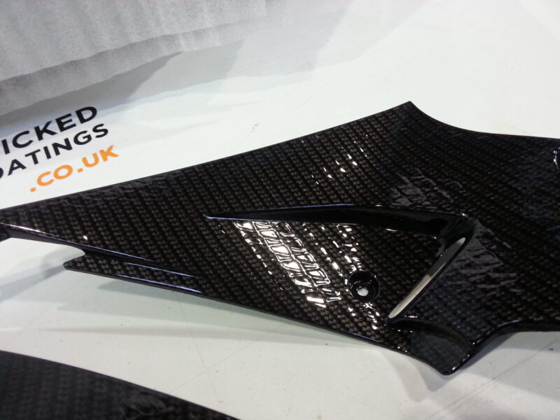 Motorbike parts coated in carbon fibre hydrographic film painted black