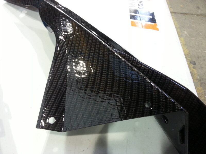 Motorbike parts coated in carbon fibre hydrographic film painted black