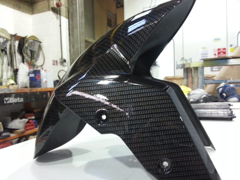 Motorbike parts coated in carbon fibre hydrographic film painted black