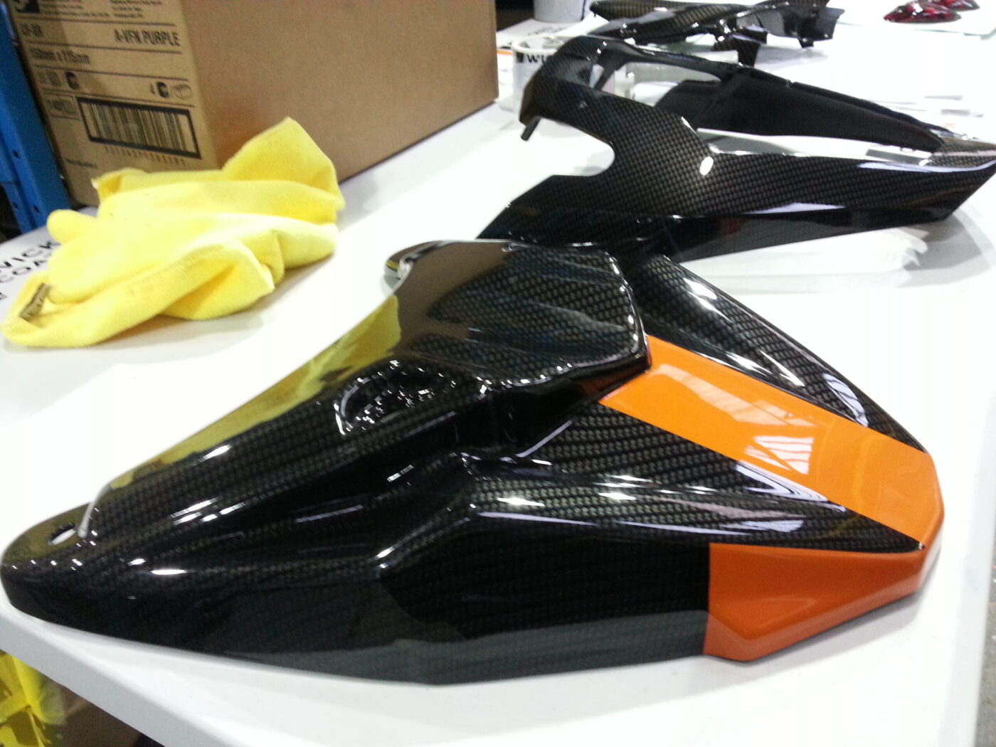 Motorbike parts coated in carbon fibre hydrographic film painted black and orange