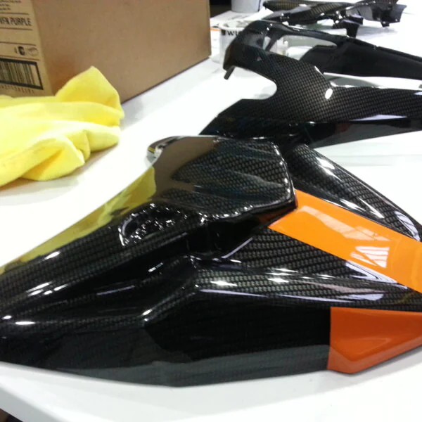 Motorbike parts coated in carbon fibre hydrographic film painted black and orange