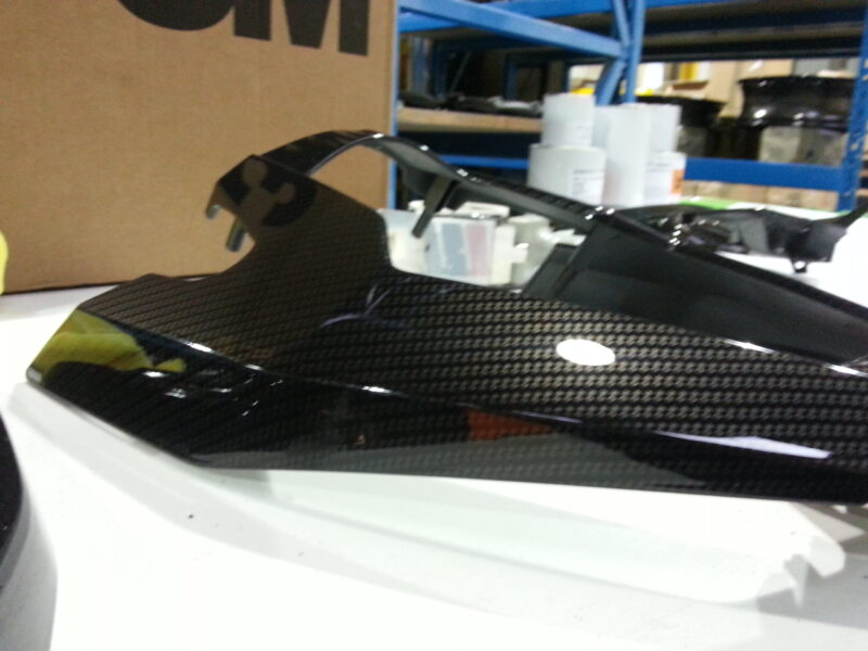 Motorbike parts coated in carbon fibre hydrographic film painted black and orange