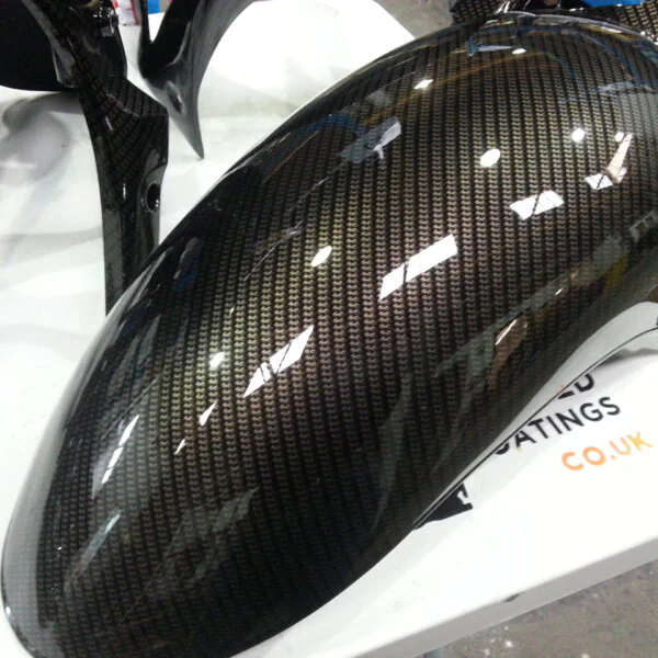 Motorbike parts coated in carbon fibre hydrographic film painted black