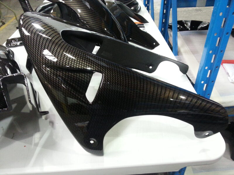 Motorbike parts coated in carbon fibre hydrographic film painted black