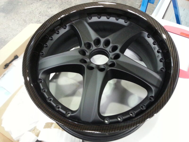 Car alloy wheels coated in carbon fibre hydrographic film painted black