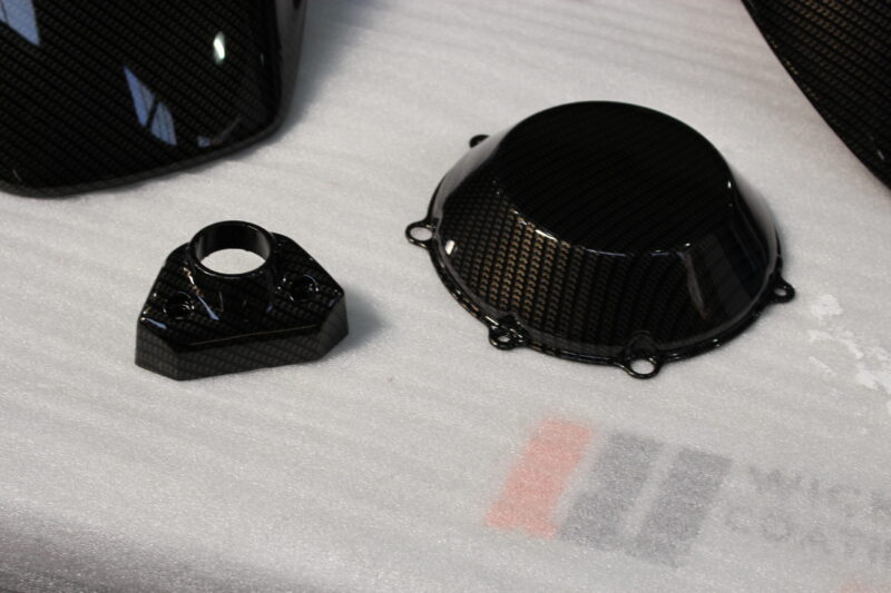 Motorbike parts coated in carbon fibre hydrographic film painted black