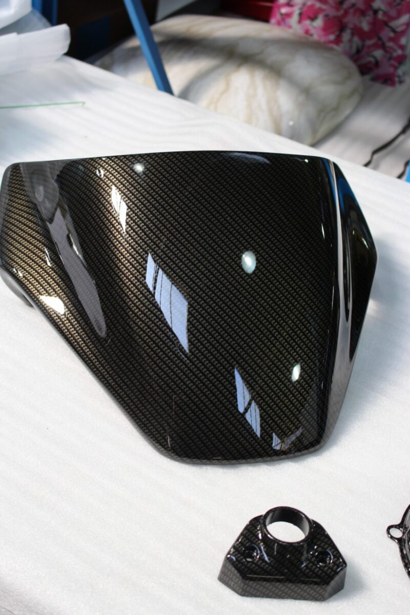Motorbike parts coated in carbon fibre hydrographic film painted black