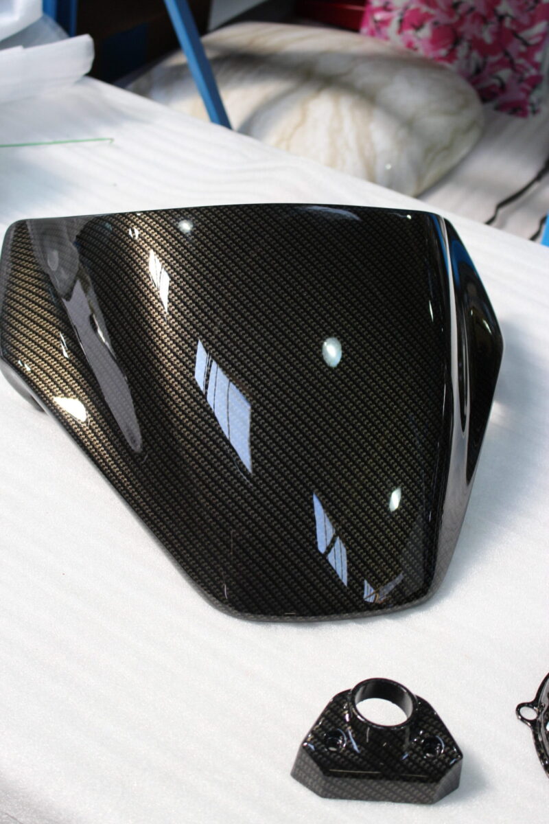 Motorbike parts coated in carbon fibre hydrographic film painted black