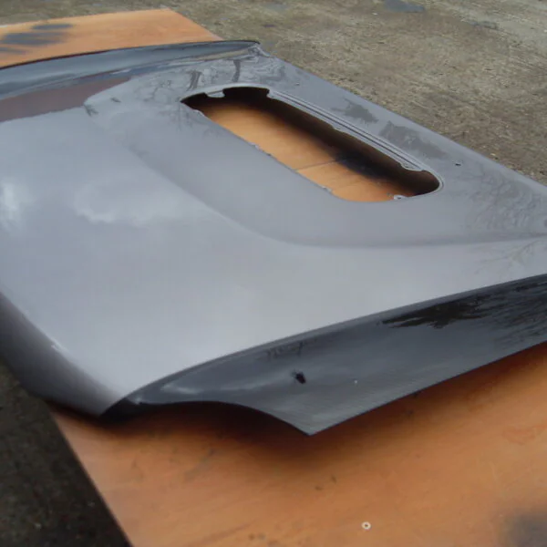 Car hood coated in carbon fibre hydrographic film painted black