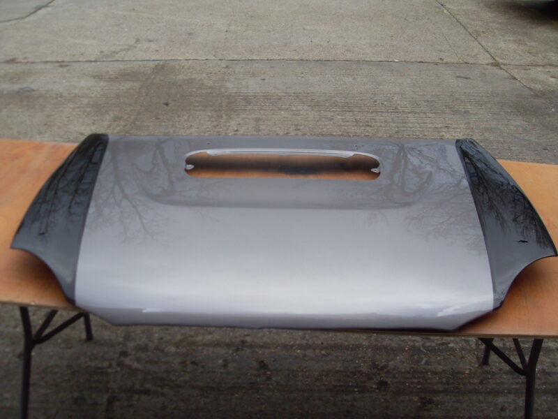 Car hood coated in carbon fibre hydrographic film painted black